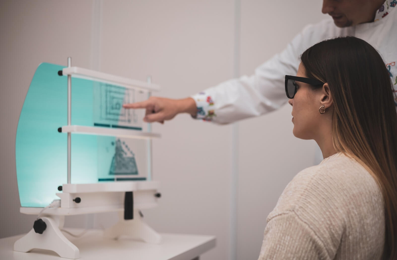 A patient at their eye doctor improving their visual skills with eye exercises during a vision therapy appointment.
