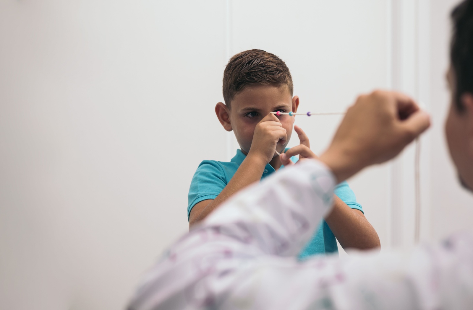 A child using a Brock string while under the guidance of a vision therapist at a vision therapy clinic