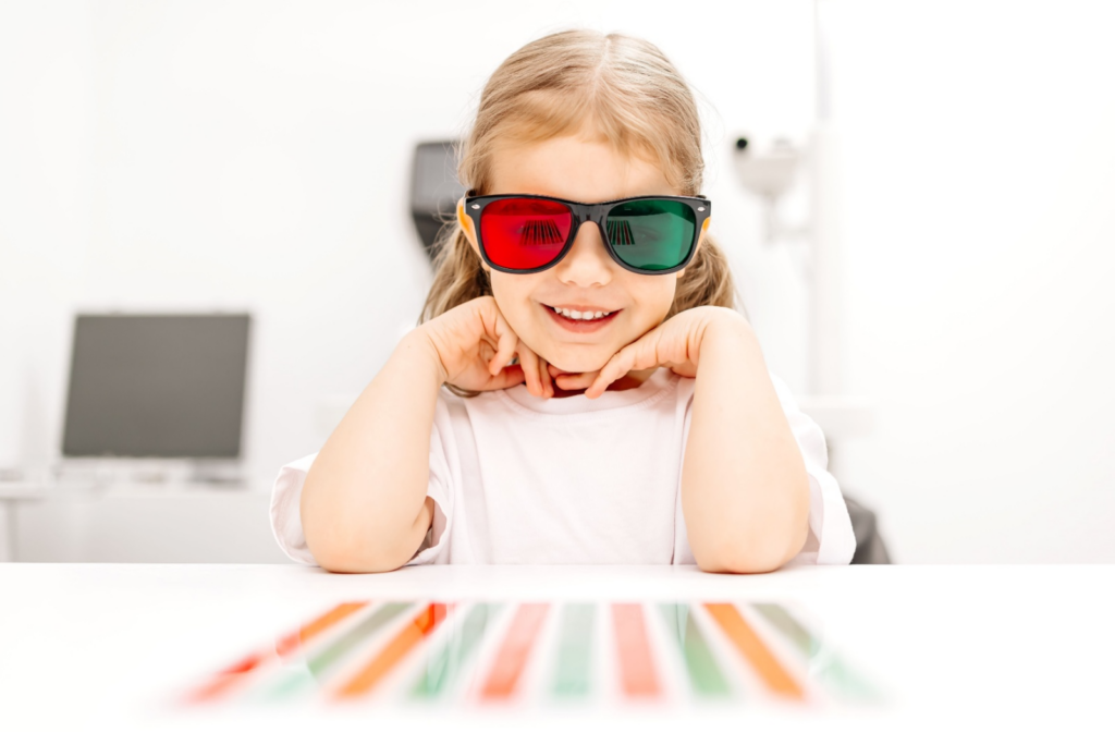 Young child wearing red and green glasses while doing vision therapy exercises.