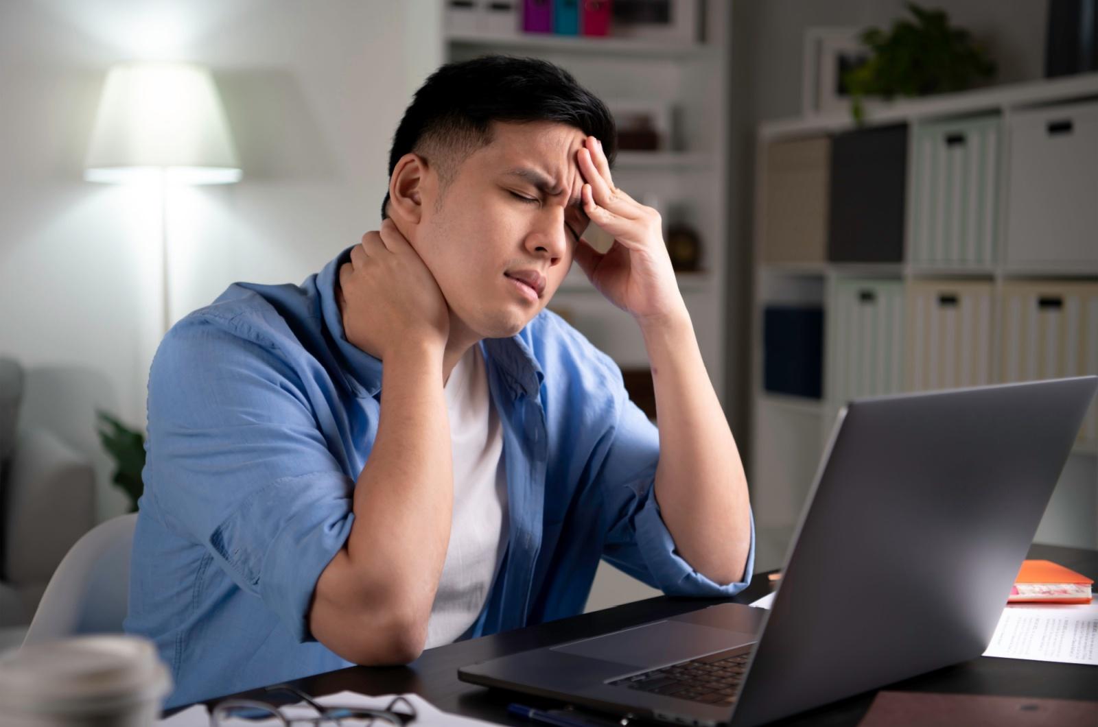 adult feeling nauseous while sitting at a desk