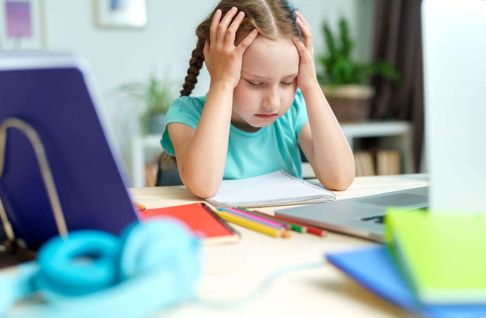 child struggling to concentrate while sitting in a classroom